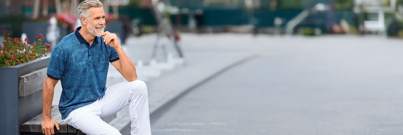 Mann mit blauem Shirt und weißer Hose