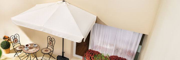 Balkontisch mit zwei Stühlen und Sonnenschirm