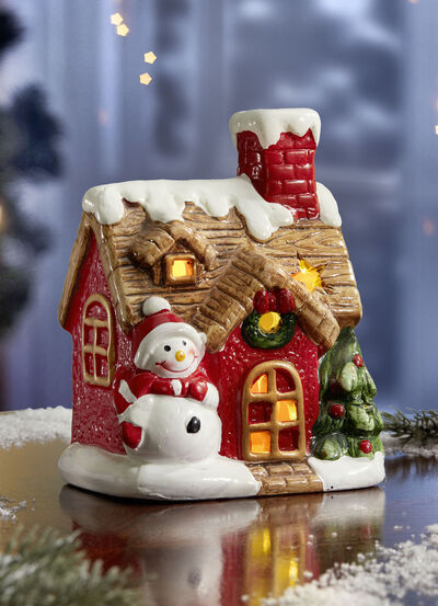 Beleuchtetes Haus mit Schneemann 
